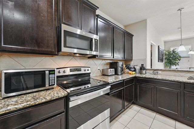 kitchen featuring appliances with stainless steel finishes, decorative backsplash, and light stone counters