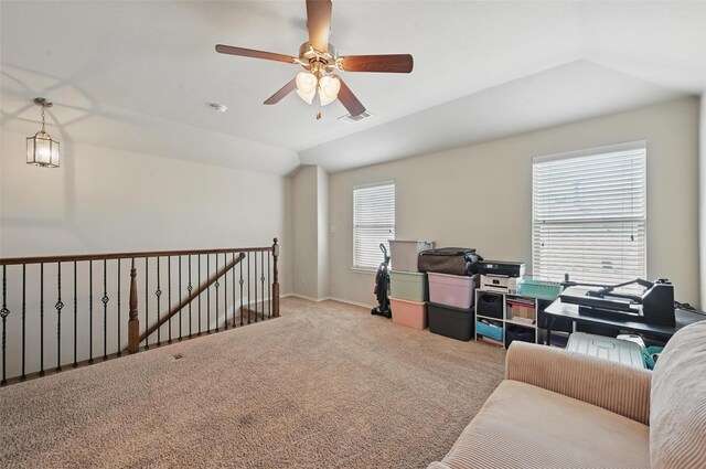 carpeted home office featuring ceiling fan, visible vents, baseboards, and lofted ceiling