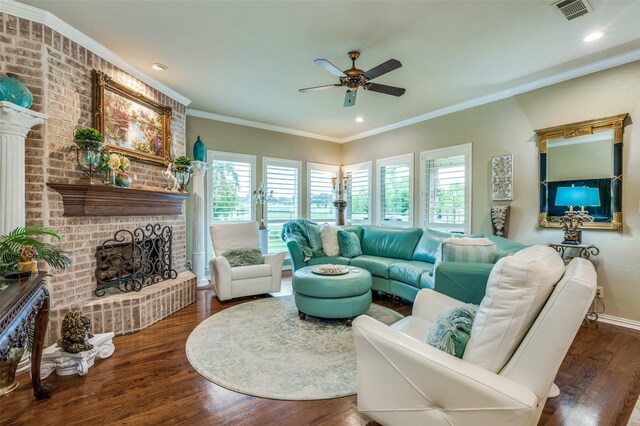 living room featuring visible vents, ornamental molding, a brick fireplace, wood finished floors, and ceiling fan