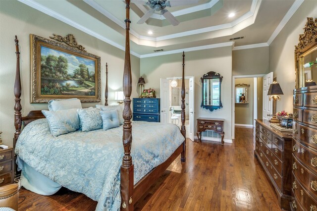 bedroom with visible vents, ornamental molding, wood finished floors, and a tray ceiling