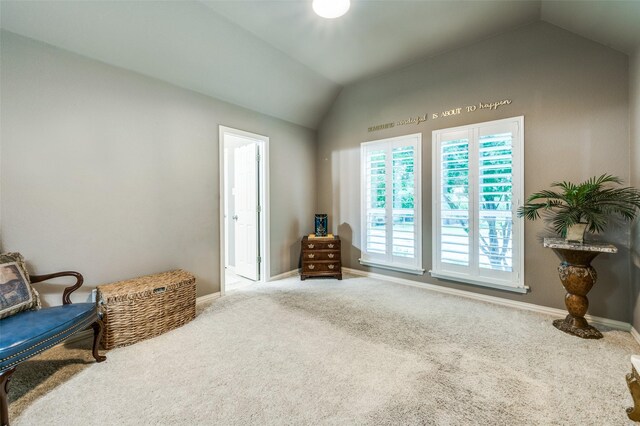 sitting room with carpet floors, baseboards, and lofted ceiling