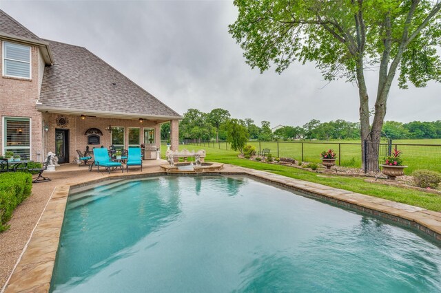 outdoor pool with a yard, a fenced backyard, and a patio area