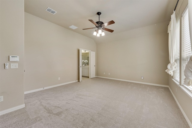 spare room featuring a ceiling fan, visible vents, light carpet, and lofted ceiling