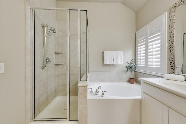 full bathroom with vanity, a bath, a stall shower, and vaulted ceiling