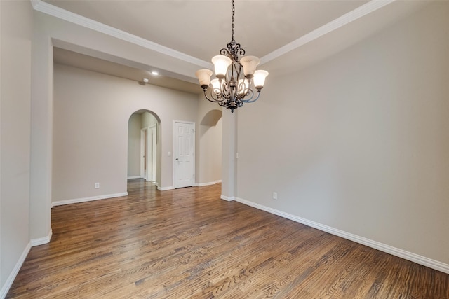 unfurnished room featuring arched walkways, baseboards, wood finished floors, and a chandelier