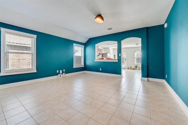 850 Levi Ln, Forney, TX 75126 - empty room with visible vents, arched walkways, light tile patterned floors, baseboards, and lofted ceiling