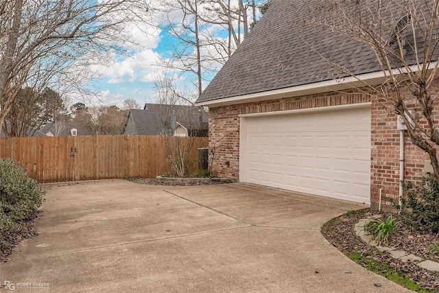2320 Hidden Cv, Haughton, LA 71037 - view of side of property featuring roof with shingles, a garage, brick siding, fence, and concrete driveway