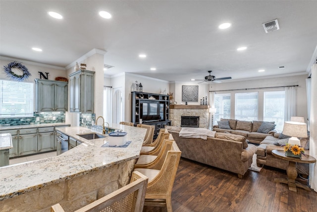 kitchen featuring gray cabinets, a ceiling fan, visible vents, a sink, and light stone counters