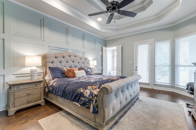 bedroom featuring crown molding, dark wood finished floors, multiple windows, and a raised ceiling