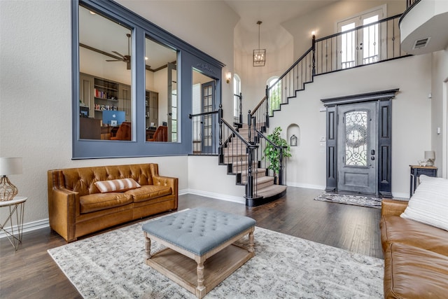 living room featuring visible vents, baseboards, stairs, and wood finished floors
