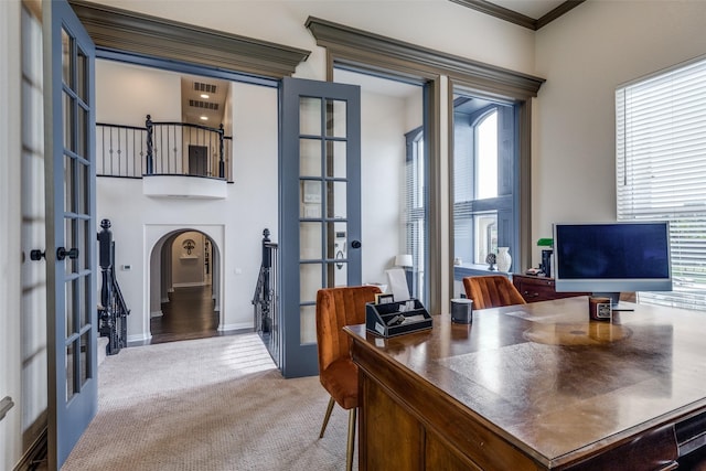 office featuring arched walkways, ornamental molding, light carpet, and french doors