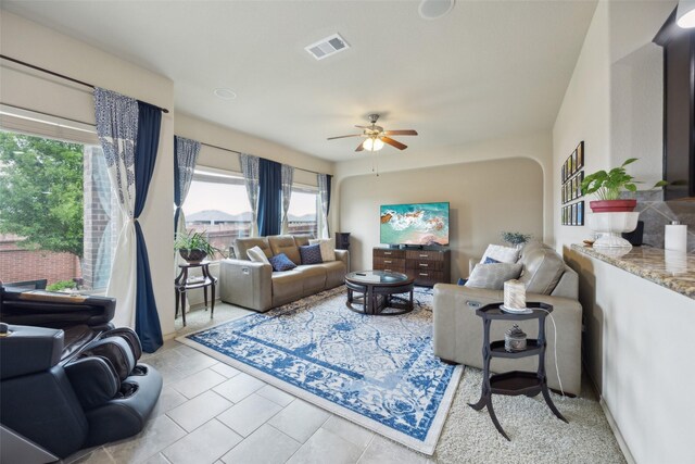 living area featuring visible vents, ceiling fan, tile patterned flooring, and a wealth of natural light