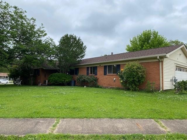 ranch-style home with a garage, a front lawn, and brick siding