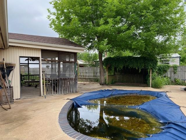 view of swimming pool with a fenced backyard, a fenced in pool, and a sunroom