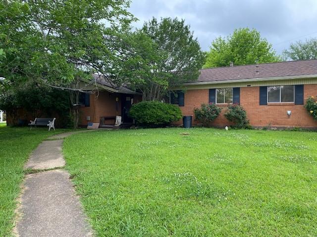 ranch-style home with brick siding and a front yard