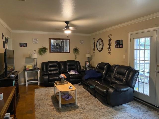 living room with ceiling fan, ornamental molding, and a healthy amount of sunlight