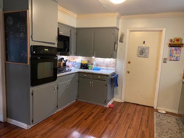 kitchen featuring crown molding, tasteful backsplash, dark wood-type flooring, gray cabinetry, and black appliances