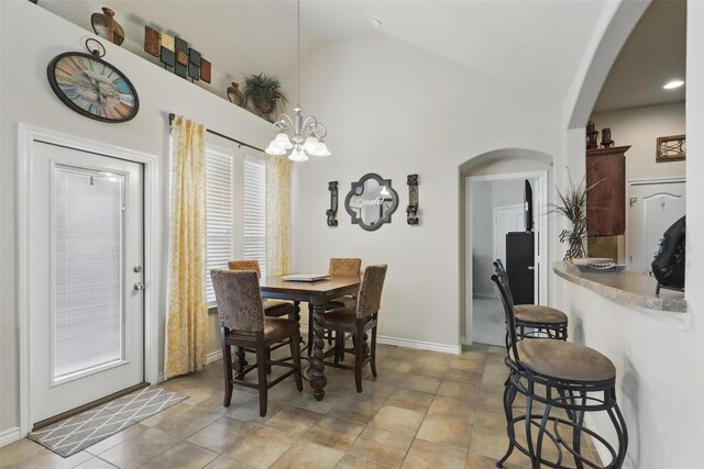 dining area featuring arched walkways, high vaulted ceiling, a chandelier, baseboards, and light tile patterned floors