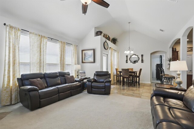 living room featuring ceiling fan, visible vents, light colored carpet, arched walkways, and high vaulted ceiling