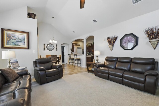 living room with visible vents, arched walkways, ceiling fan with notable chandelier, and lofted ceiling