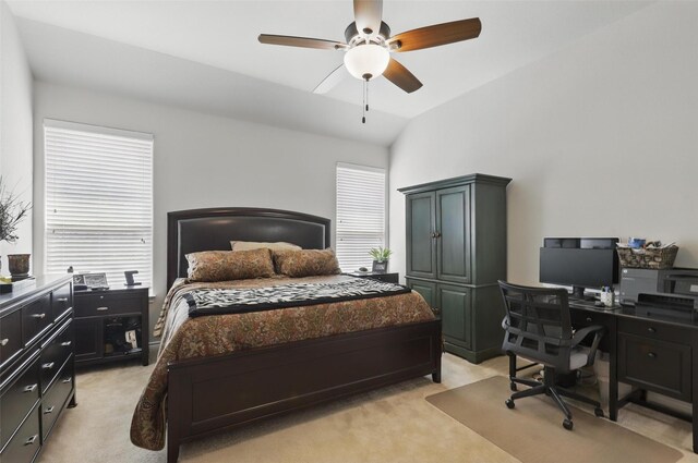 bedroom featuring multiple windows, light carpet, vaulted ceiling, and ceiling fan