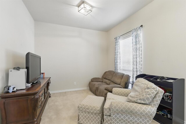 living area with light colored carpet and baseboards