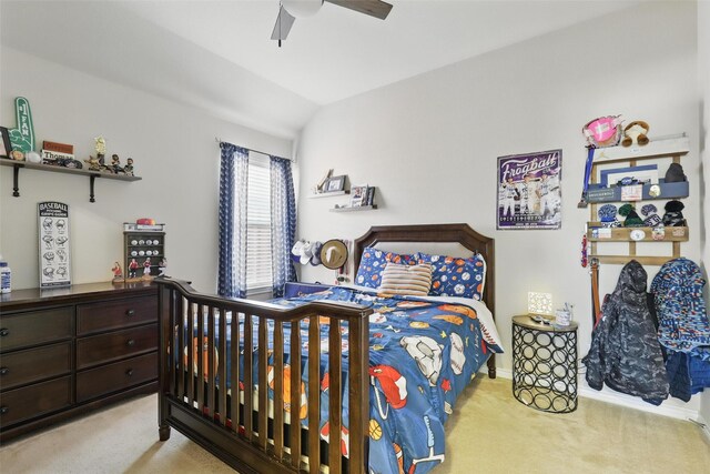 carpeted bedroom with a ceiling fan and vaulted ceiling