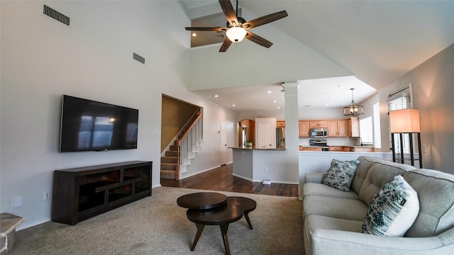 living room with a ceiling fan, high vaulted ceiling, visible vents, and baseboards