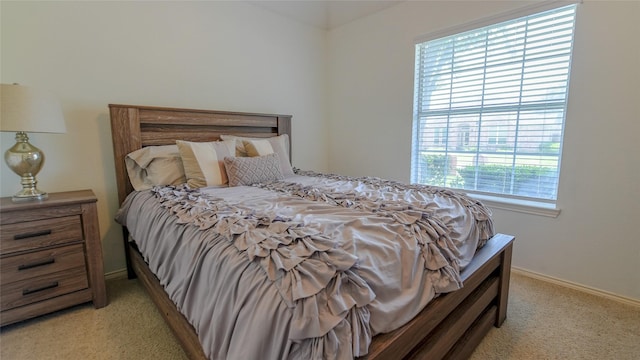 bedroom featuring baseboards and light colored carpet