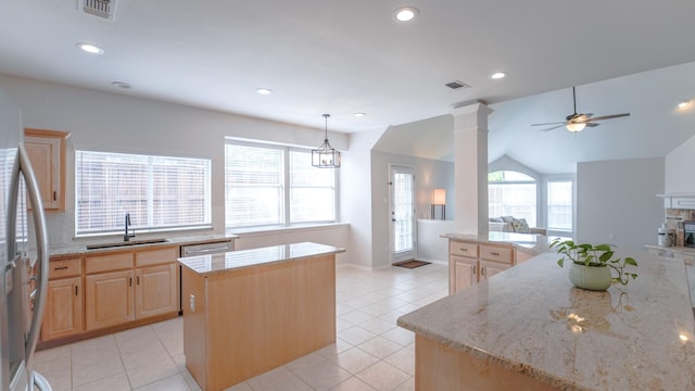kitchen with a sink, light brown cabinets, a center island, open floor plan, and visible vents