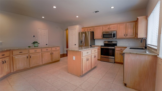 kitchen featuring visible vents, a sink, appliances with stainless steel finishes, and light brown cabinets