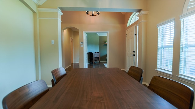 dining space with arched walkways, baseboards, and a wealth of natural light