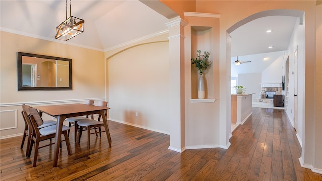 dining area featuring arched walkways, a ceiling fan, vaulted ceiling, and dark wood-style flooring