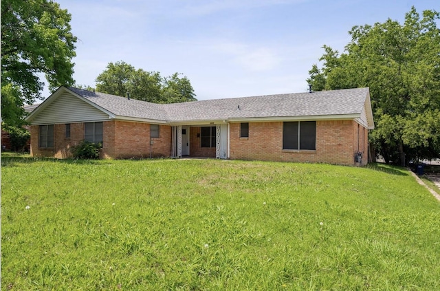 ranch-style house featuring brick siding, a shingled roof, and a front lawn