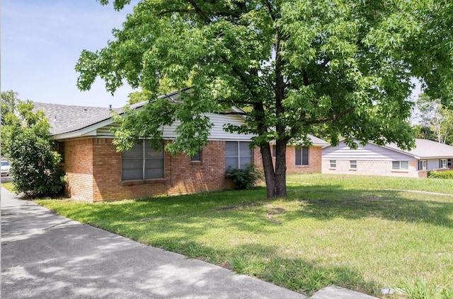 view of front of property with brick siding and a front lawn