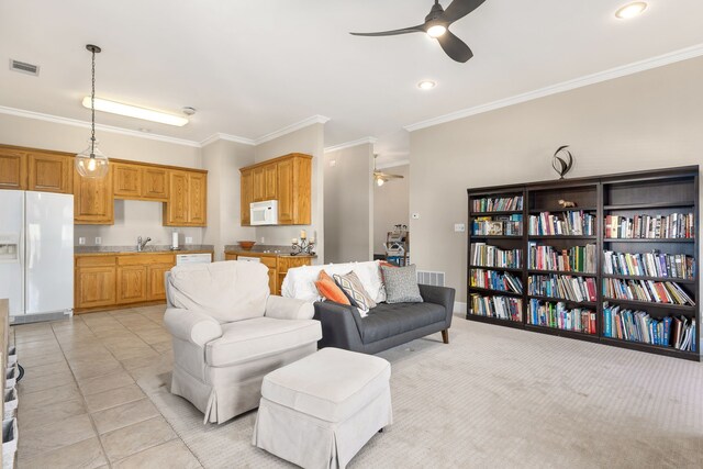 living room with crown molding, a ceiling fan, and visible vents