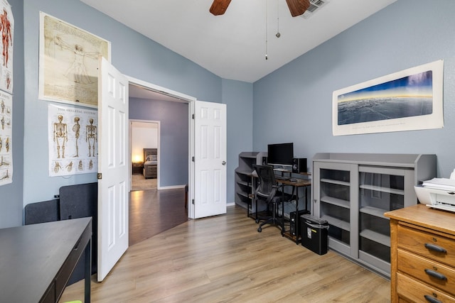 home office with visible vents, a ceiling fan, and light wood-style flooring