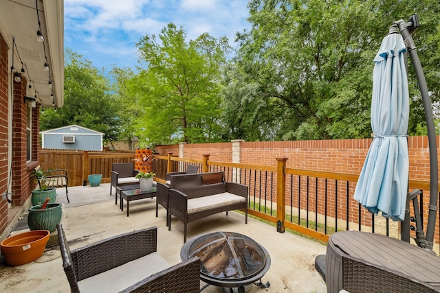view of patio / terrace with a fenced backyard and an outdoor living space with a fire pit