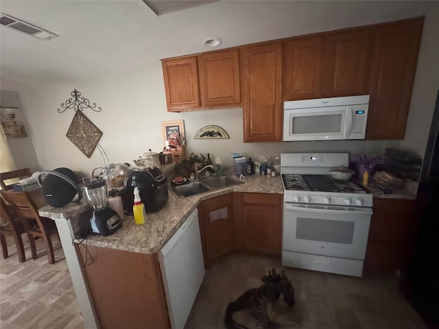 kitchen with a sink, brown cabinetry, white appliances, and visible vents