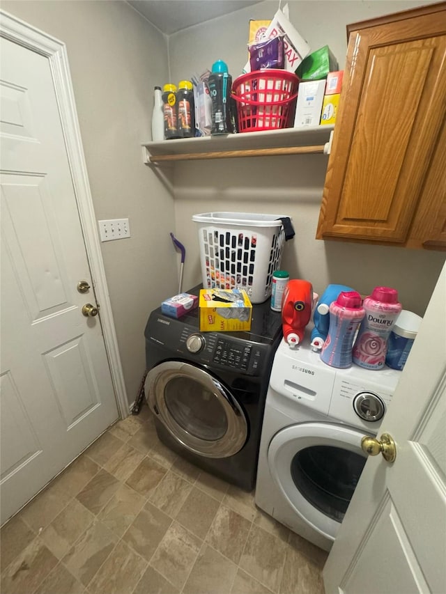 clothes washing area featuring cabinet space and separate washer and dryer