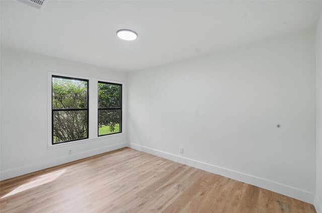spare room featuring baseboards, visible vents, and light wood-type flooring