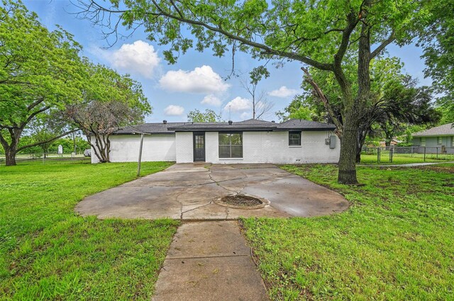 rear view of property with fence, a patio, a yard, and brick siding