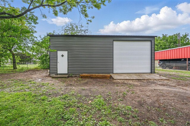 view of outbuilding with fence and an outbuilding