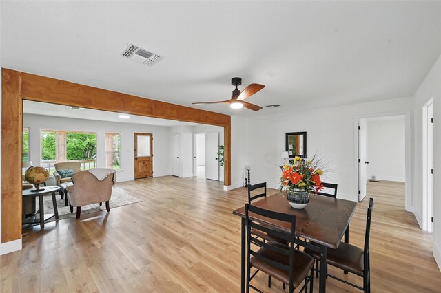 dining space featuring visible vents, light wood-style floors, ceiling fan, and baseboards