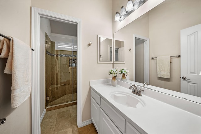 bathroom with vanity, baseboards, and a shower stall