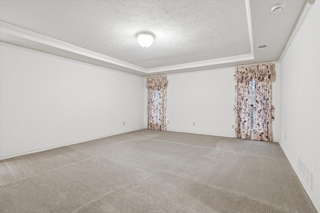carpeted spare room featuring crown molding, a tray ceiling, a textured ceiling, and visible vents