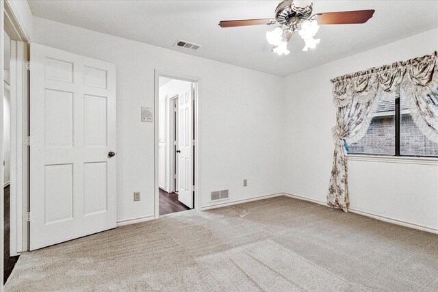 unfurnished bedroom featuring carpet floors, baseboards, a ceiling fan, and visible vents