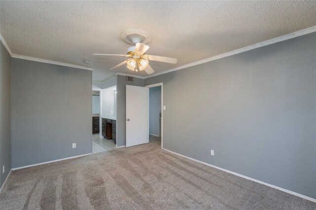 unfurnished bedroom featuring crown molding, visible vents, baseboards, a textured ceiling, and carpet flooring