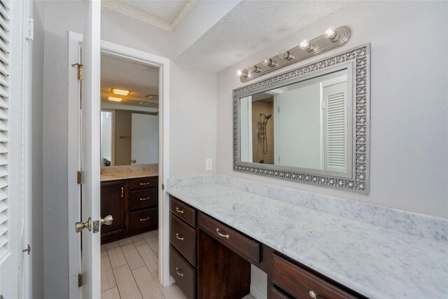 bathroom featuring vanity, a textured ceiling, and walk in shower