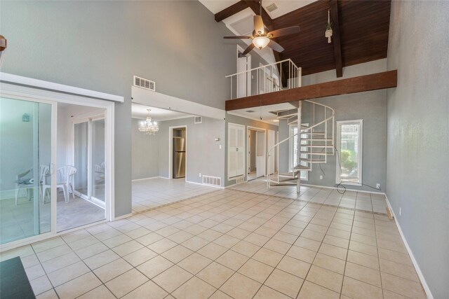 unfurnished living room with visible vents, beam ceiling, high vaulted ceiling, stairway, and light tile patterned floors